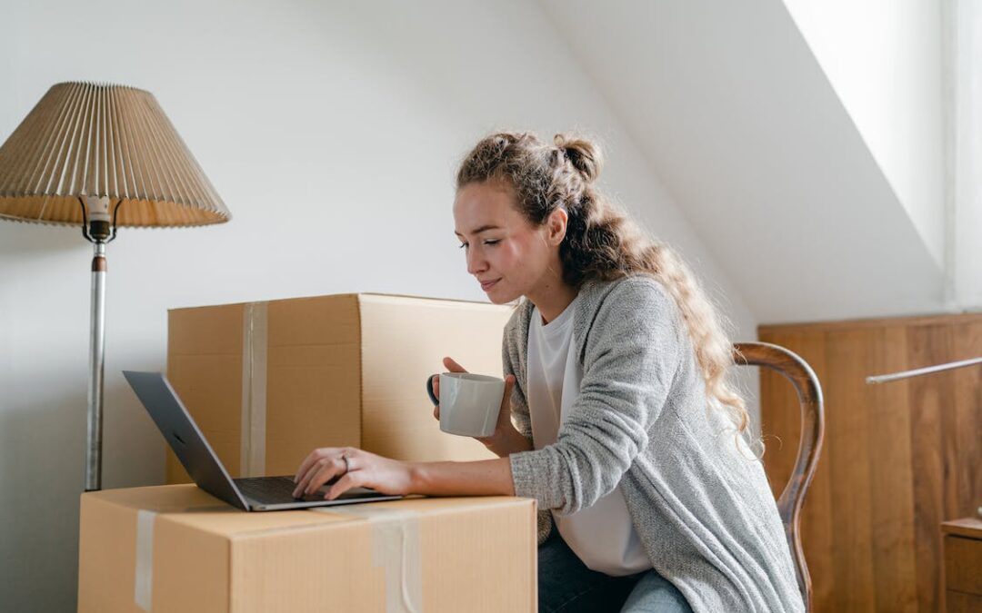Woman drinking coffee while researching how to make money by reselling your old furniture and appliances on her laptop