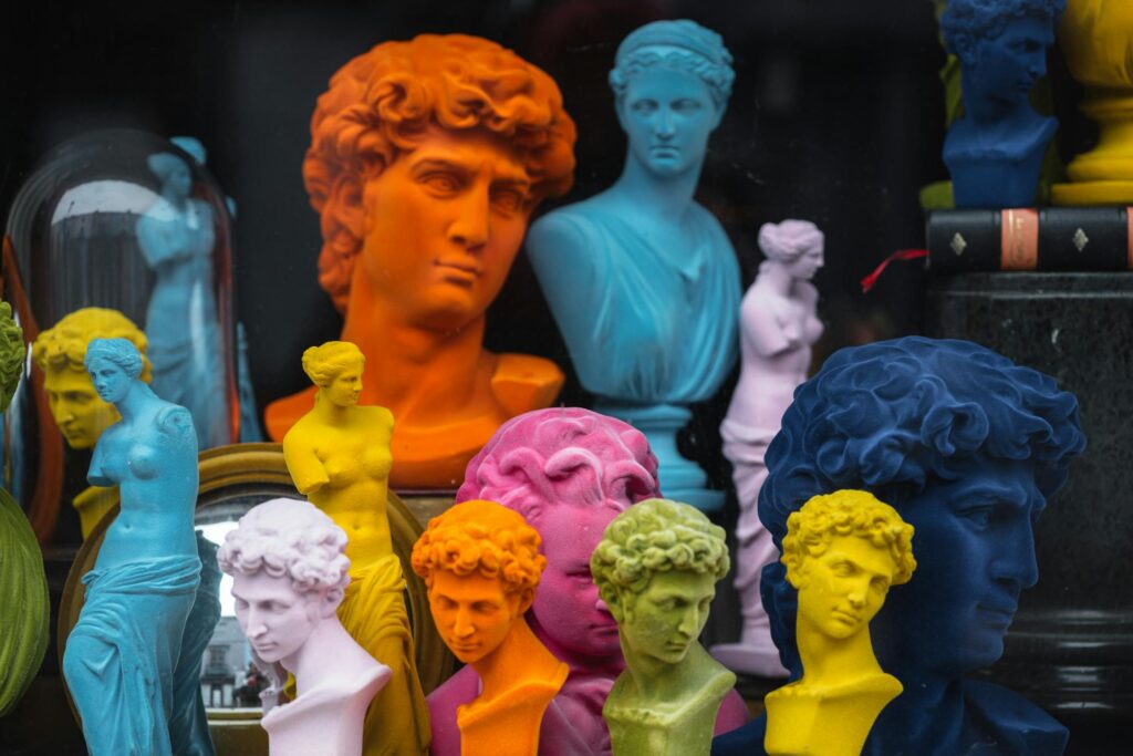 Several colorful statues and busts in a thrift store