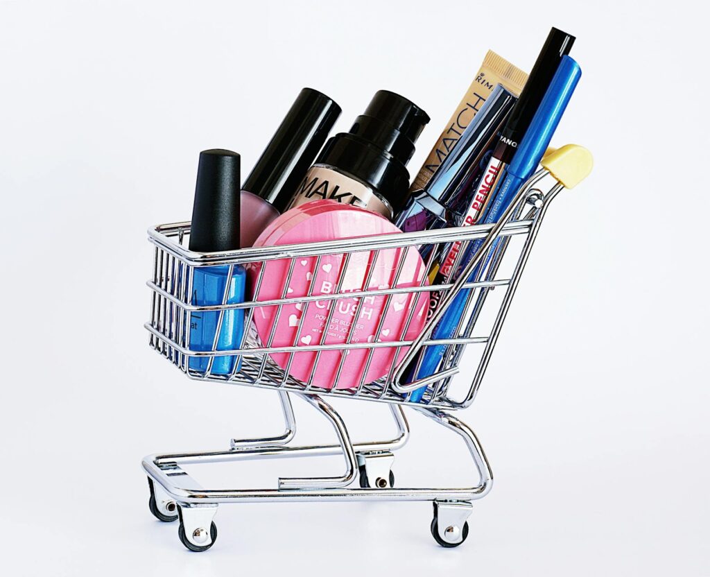 Assorted cosmetics in a small shopping cart.